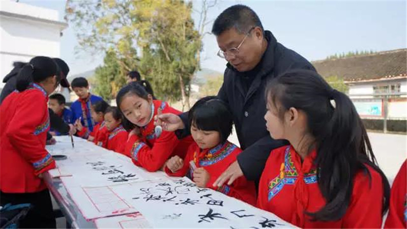 2014年12月带队参加中国文联“到人民中去——湖南古丈小分队慰问采风活动”。图为辅导小学生书法.jpg